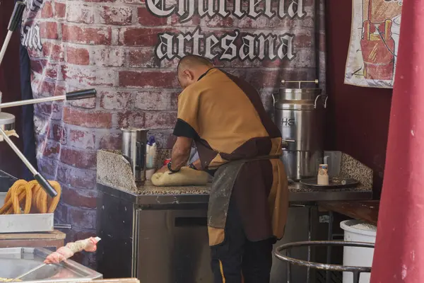 Esnaf, ortaçağ pazarındaki tezgahında churros kızartmak için hamur hazırlıyor.