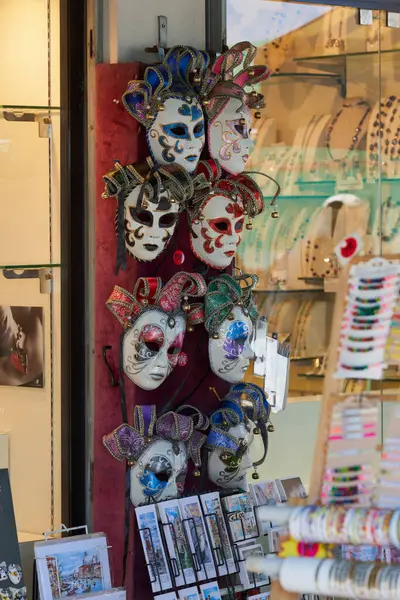 stock image Ornate Venetian masks adorned with glitter and feathers showcased in a store, embodying Carnival spirit in Venice