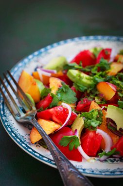 Taze bahar salatası. Avokado, domates, şeftali, kırmızı soğan ve bitkiler. 