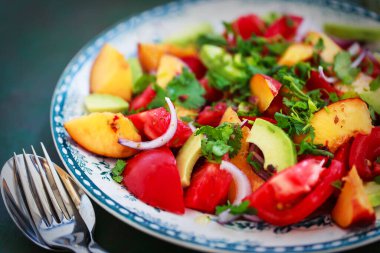 Taze bahar salatası. Avokado, domates, şeftali, kırmızı soğan ve bitkiler. 