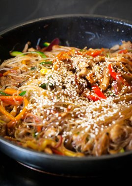 Tavada tavuk ve sebzeli Asya usulü kızarmış erişte.