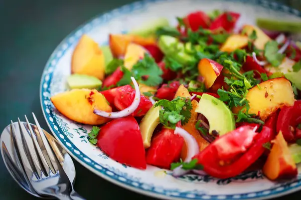 Taze bahar salatası. Avokado, domates, şeftali, kırmızı soğan ve bitkiler. 
