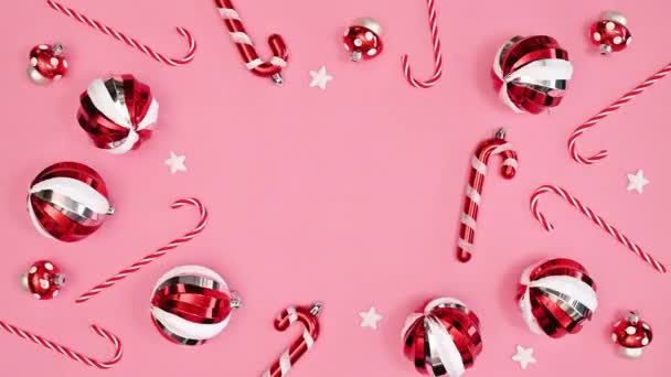 빨간색 크리스마스 장식은 분홍색 배경에 크리스마스 인사말 카드를 만든다 — 비디오