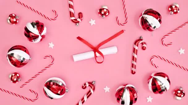 复制空间圣诞贺卡与纸和传统可爱的红色饰物在粉红的背景 平躺在床上停止运动 — 图库视频影像