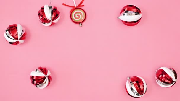漂亮可爱的红色圣诞装饰品 用粉色背景制作圣诞贺卡 停止运动 平躺在床上 — 图库视频影像