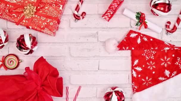传统的红色圣诞贺卡 带有白色背景的礼物和装饰品 平躺在床上停止运动 — 图库视频影像