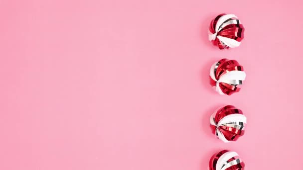 Enfeites Natal Vermelho Brilhante Branco Prata Rolando Fundo Rosa Pastel — Vídeo de Stock