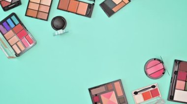 Pastel mavi tema üzerinde göz farları olan yaratıcı makyaj alanı arka planı. Hareketi durdur. Düz yatıyordu