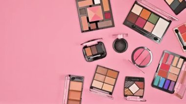 Makyaj malzemelerinin yarısı pastel pembe arka planda. Düz yatıyordu. Hareket kopyalama alanını durdur