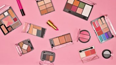 Pastel pembe arka planda yanıp sönen makyaj kalıpları. Düz yatıyordu. Hareketi durdur