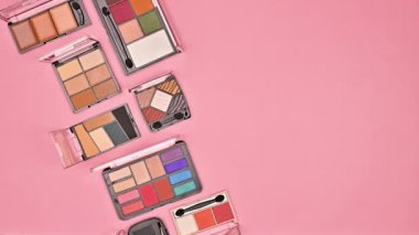 Pastel pembe arka plandaki göz gölgelerinin yaratıcı bileşimi. Düz yatıyordu. Hareketi durdur