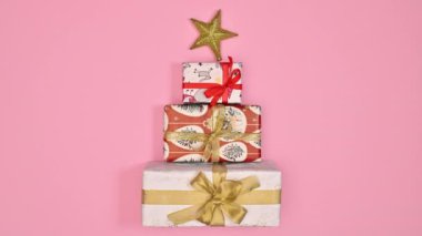 Üzerinde yıldız olan Noel hediyelerinden yapılmış yaratıcı bir Noel ağacı. Hareketi durdur. Düz yatıyordu