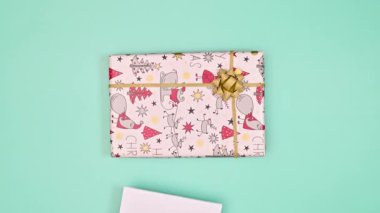 Pastel mavi arka planda fotokopi kağıdı olan bir Noel hediyesi. Düz yatıyordu. Hareketi durdur