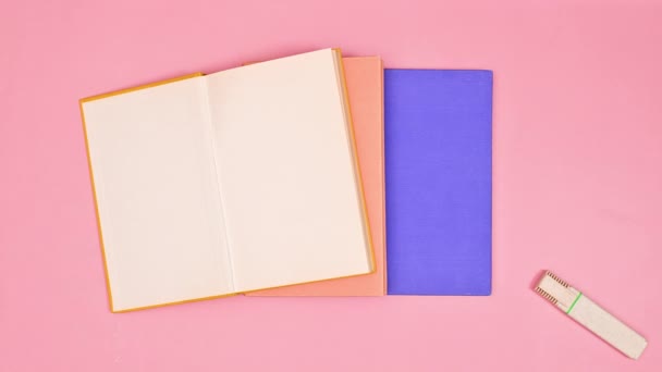 Барвисті Шкільні Канцтовари Книги Являються Пастельно Рожевому Тлі Пласка Лежала — стокове відео
