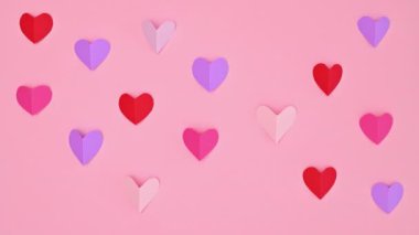 Blinking hearts on Valentine's day background on pastel pink theme. Stop motion. Flat lay pattern