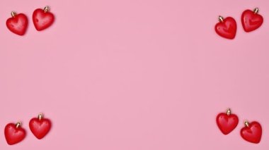 Valentine's day background with hearts appear and copy space on pastel pink background. Stop motion. Flat lay
