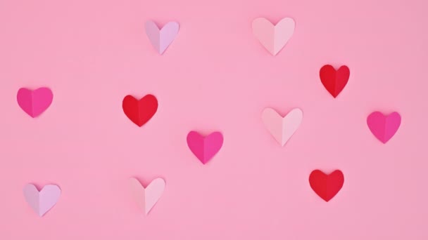 バレンタインデーの心のパステルピンクの背景にパターンを作る 平置きだ 動くな — ストック動画