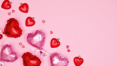 Valentine's day background with moving hearts with copy space on pastel pink background. Flat lay. Stop motion