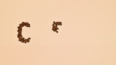 Kahve çekirdeği ve kahve fincanının pastel turuncu arka planda yazılı olduğu yaratıcı kahve konsepti. Dur hareketi düz yatıyordu