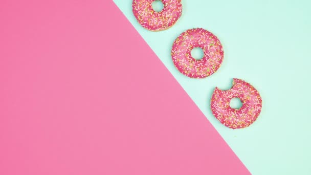 Creatieve Roze Pastelblauwe Achtergrond Met Kopieerruimte Aardbei Geglazuurde Donuts Draaien — Stockvideo