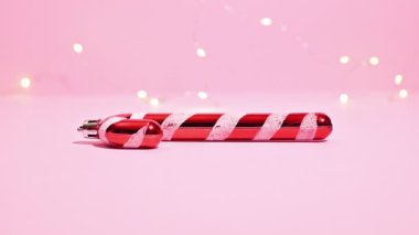 Şeker Çubuğu Sihirbazlığı: Pastel Pembe Arkaplanda Işıklı Bir Şeker Çubuğunun Durma Hareketi Videosu