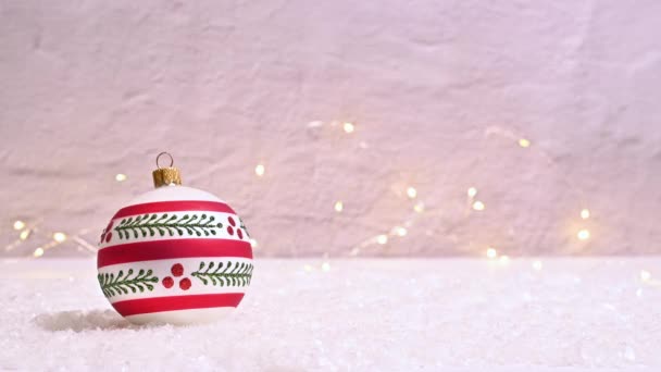 一个迷人的白色和红色的圣诞装饰品在雪地上闪烁着停止的灯光 — 图库视频影像