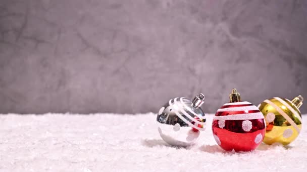 冬のワンダーランドマジック クリエイティブカラフルなクリスマスオーナメントアレンジメントは ストップモーションで雪でシルバーバックグラウンドに表示されます — ストック動画