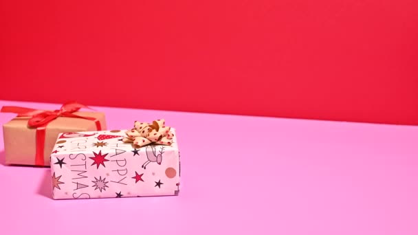 Weihnachtsharmonie Reizvolles Arrangement Von Geschenken Auf Pastellrosa Und Roter Festleinwand — Stockvideo