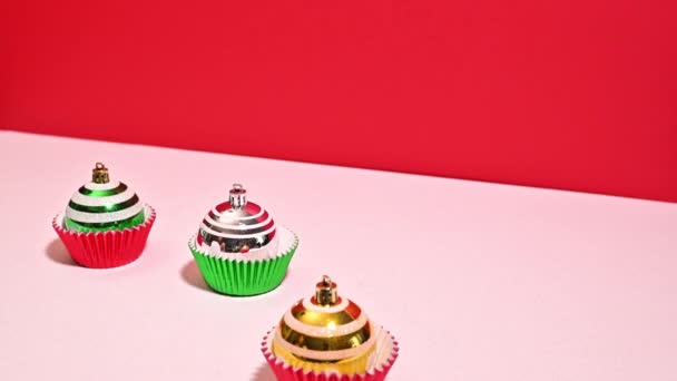 お祝いの花粉 グリーンとレッドカップケーキのバスケットをグリッタークリスマスオーナメントで飾る停止動き — ストック動画