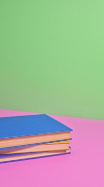 Dikey Duruş Hareketi Bir Pastel kitap kulesi inşa ediyor. Kitapların solgunluğunu sırala