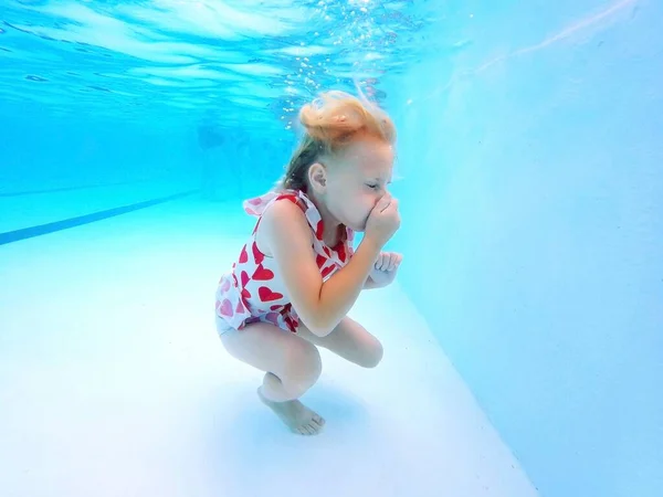 Una Niña Está Aprendiendo Nadar Bajo Agua Mientras Cierra Los — Foto de Stock