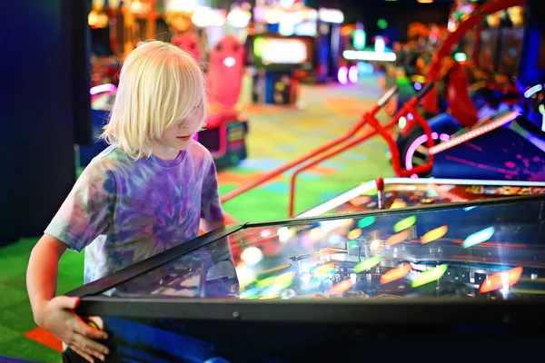 一个10岁的小男孩正在一个五彩缤纷的电子游戏拱廊里玩弹球 — 图库照片