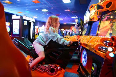 Küçük bir çocuk video oyununda motosiklet sürerken eğleniyor..