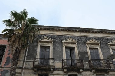 Büyüleyici binalar, geleneksel mimarinin sergilendiği Giarre, Sicilya sokaklarına dizilmiştir. Sahne, sıcak Akdeniz güneşinin altında kasabanın hayat dolu yaşamını yakalıyor..