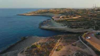 St. Peter Havuzu yakınlarındaki kayalıklara ve uçurumlara insansız hava aracı manzarası. Güç istasyonu, iskele, gemiler. Malta adası
