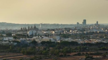 Modern binaların ve kilisenin insansız hava aracı görüntüsü, gün batımı zamanı. Malta adası
