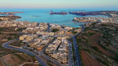Maltese limanının ve şehrin gün batımı görüntüsü, görünürde tekneler. Freeport, Malta adası