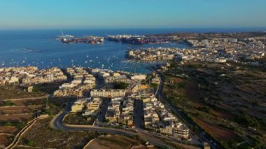 Birzebbuga şehrinin ve limanın gün batımı görüntüsü, görülecek tekneler. Freeport, Malta adası
