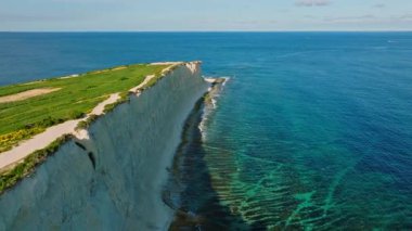 Malta adası. Yeşil tepeler, tarlalar, kayalar ve kayalıklar, deniz, dalgalar