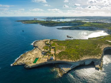 Malta kırsalının insansız hava aracı görüntüsü. Yeşil tepeler, tarlalar, kayalar ve kayalıklar