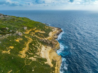 Malta adasının insansız hava aracı manzarası. Yeşil tepeler, tarlalar, kayalar, deniz