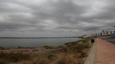 İspanya 'da dingin bir nehrin üzerinde, yağmur başlamadan hemen önce dramatik bir atmosfer yaratan koyu ve ağır bulutların 4K videosu..