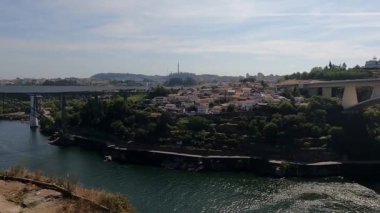 Portekiz 'in Porto kentindeki ikonik köprü, Douro Nehri ve büyüleyici turistik bölgelerdeki evlerin geniş manzarasının keyfini çıkarın. Bu büyüleyici görüntü Porto 'nun canlı güzelliğini ve zengin kültürünü gözler önüne seriyor..