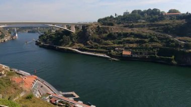 Porto, Portekiz 'in geniş açılı görüntüsü şehrin çarpıcı mimarisini, tarihi binalarını ve manzaralı nehir manzarasını yakalıyor. Canlı şehir manzarası ikonik Dom Lus I Köprüsü ve pitoresk çatılar tarafından tamamlanır..