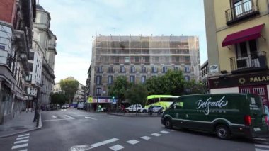 Yeşil bir minibüsün hareketli bir caddeye dönüşünü izleyin, şehir ve şehir trafiğinin dinamik hareketini yakalayın..