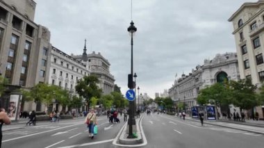 Bulutlu, gri gökyüzünün altındaki Madrids caddelerinin cazibesini keşfedin. Bu görüntüler, kentin dingin ve sakin kentsel ortamında yürürken şehrin sakin havasını yansıtıyor.. 