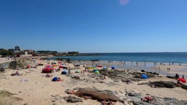 Güneşli Kaçışlar: Kalabalık bir plajda canlı yaz günleri güneşin sıcaklığını hissedin ve kalabalık bir plajda yazın uğultusunu hissedin. Yaz tatillerinin, sahile gidenlerin ve tatil sezonlarında kıyı eğlencesinin enerjisini göstermek için mükemmel..