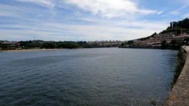 Altın Yansımalar: Porto 'nun Sahili' nde güneş ışığı Uzak Tecrübe Şehrinde şehir manzarası ile birlikte Porto 'nun sahil şeridinin büyüleyici güzelliği, arka planda parlak şehir silüeti ile plajın altın kumlarından yansıyor.. 