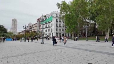 Gri, bulutlu bir günde Madrid 'de kalabalık bir meydanda yürüyen ve şehrin göbeğindeki kentsel yaşamın dinamik atmosferini yakalayan insanların canlı bir görüntüsü. Şehir hayatı, hava durumu ve günlük etkinlik temaları için mükemmel.. 