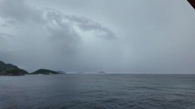 Erken gün ışığı, engebeli bir okyanus sahil şeridini aydınlatarak, ağır bulutları aşmaya çalışıyor.. 